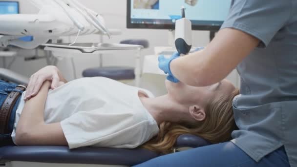 치과 교정 의사는 치과 환자를 스캔하기 위해 3 차원 구강 스캐너를 사용 한다. 장비를 갖춘 현대 치과 클리닉. 치과 치료와 건강 관리 개념 — 비디오