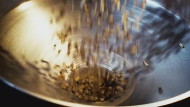 Los granos de café verdes crudos se vierten en la tostadora. Granos de café verdes sin tostar sobre fondo de saco. Los granos de café crudos caen desde arriba — Vídeo de stock