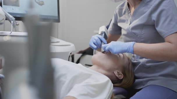 Doktor skenuje zuby pacientů na klinice. Zubař drží v ruce ruční 3D skener na čelist a ústa. Zubní zdravotní stav. Vytvoří 3D model zubů a dásní na lékařském monitoru — Stock video