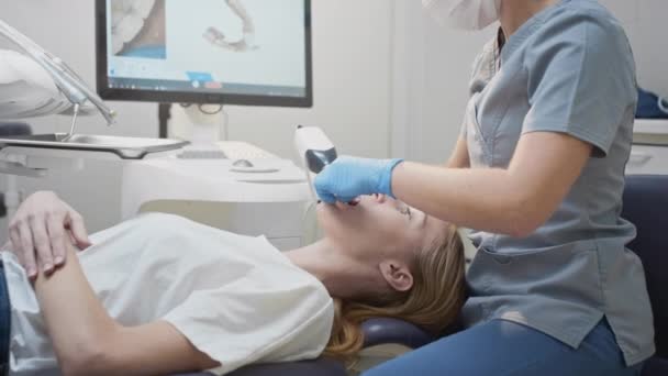 Doktor kadın, kadın bir hastanın dişlerinin 3 boyutlu taramasını yapar. Çenenin 3 boyutlu modelini yapar, ağzı iyileştirir. Diş Kliniği. — Stok video