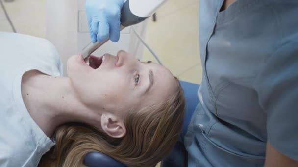 Lekarz skanuje zęby pacjentów w klinice. Dentysta trzyma w ręku ręczny skaner 3D na szczękę i usta. Zdrowie stomatologiczne. Tworzy model 3D zębów i dziąseł na monitorze medycznym — Wideo stockowe
