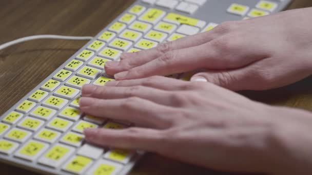 Közelkép egy számítógép billentyűzetről Braille-lel. Egy vak lány szavakat gépel a gombokra a kezével. Látássérült személyek számára készült technológiai eszköz — Stock videók
