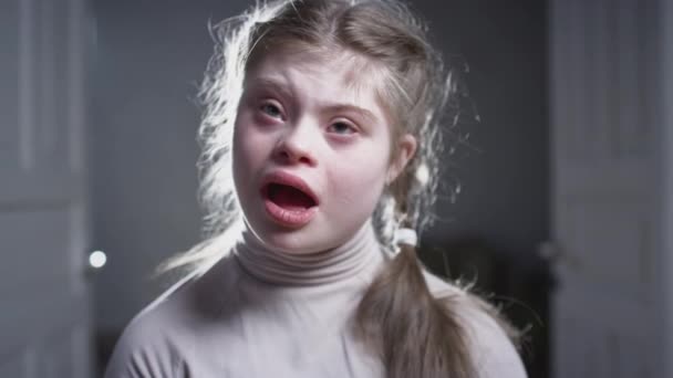 Portrait of a happy girl with down syndrome. Cheerful kid smiling at camera. A person with special needs. Chromosomal genetic disorder in a child. — Stock Video