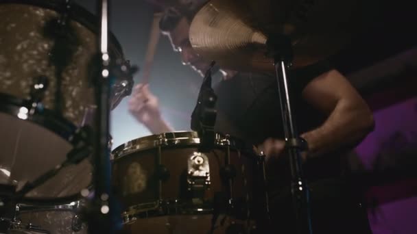 Een jonge aantrekkelijke mannelijke drummer speelt met stokken op een drumstel. Slaat op metalen bekkens of Crash. Home repetitie studio voor het opnemen van geluid — Stockvideo