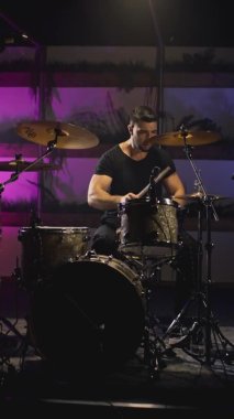 Genç ve çekici bir erkek davulcu davul setinde sopalarla oynar. Metal zillerde ya da çarpışmalarda hit oluyor. Ses kaydı için ev provası stüdyosu