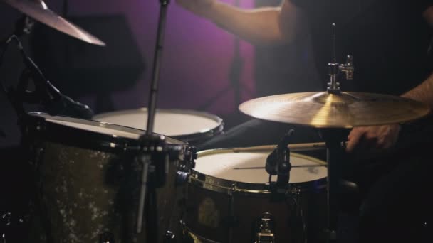 Een jonge aantrekkelijke mannelijke drummer speelt met stokken op een drumstel. Slaat op metalen bekkens of Crash. Home repetitie studio voor het opnemen van geluid — Stockvideo