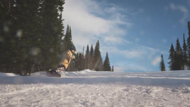 Pengendara profesional menghancurkan tanjakan ski bersalju. Menutupi kamera dengan salju. Mencipratkan salju ke lensa. Snowboarder mengukir di lereng ski — Stok Video