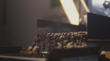 Kavrulmuş kahve çekirdekleri soğutucudan düşer. Arabika fasulyeleri dökülür ve döndürülürler. Endüstriyel kızartma ve üretim, kahve endüstrisi