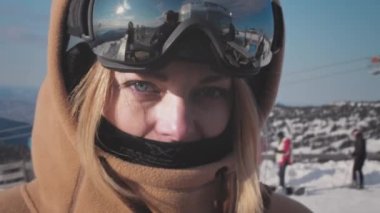 Portre: kapüşonlu, gökyüzü maskeli ya da gözlüklü güzel kız snowboardcu. Eğlence olsun diye kameraya bakıyorum. Kış tatilinin ve seyahat macerasının tadını çıkarıyorum..