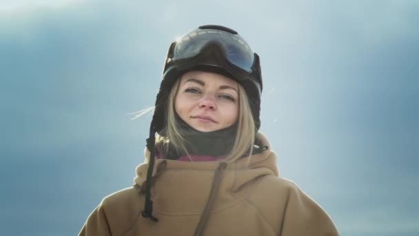 Piękna dziewczyna snowboardzistka tańczy. Szczęśliwej jazdy na nartach. W kapturze i kasku ochronnym. Podróż do kurortu zimowego, przygoda — Wideo stockowe