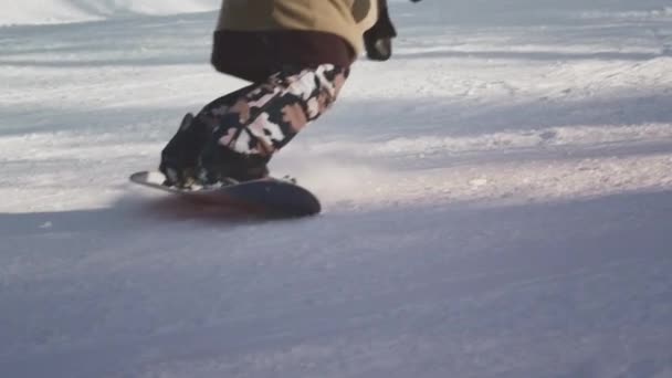 Meisje snowboarder maakt een sprong. Van de skipiste af. Snowy track voor snowboarden — Stockvideo