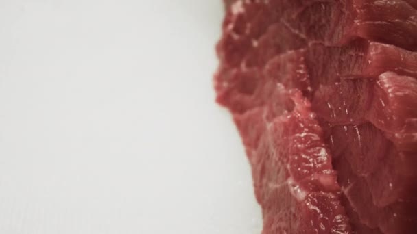 A man cook cuts a fresh red raw fillet in a butchers shop with a kitchen knife. Slices Premium ribeye meat or marbled beef. Macro shot — Stock Video