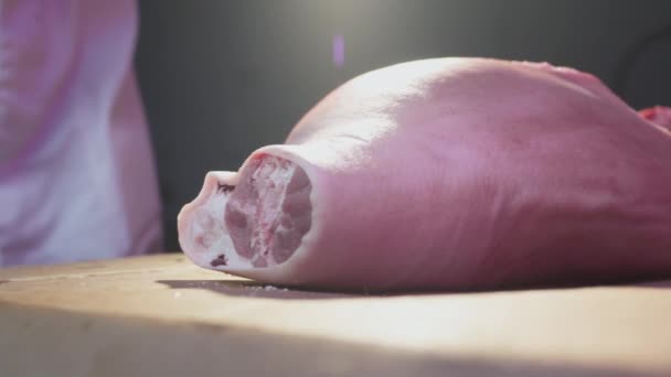 Industrielle Verarbeitung von Fleisch. Ein Metzgermeister schneidet in einer Metzgerei mit einer Axt ein Stück eines Tierbeins ab. Ribeye oder marmoriertes Rindfleisch. Zeitlupe — Stockvideo