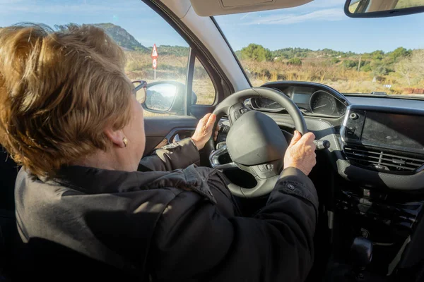 Senior woman driving a car on a sunny day