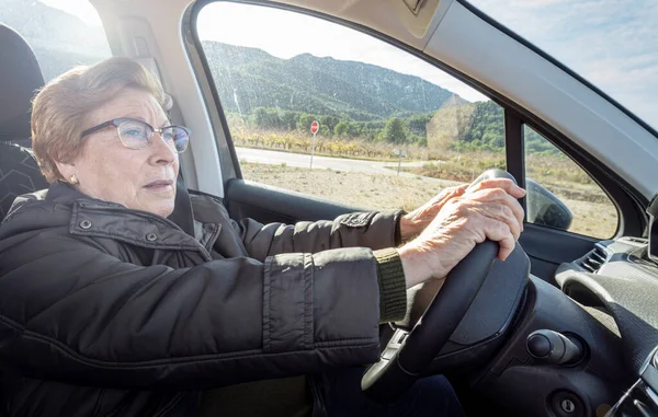Senior woman driving a car on a sunny day