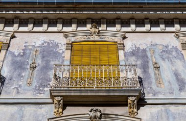 Balkonlu ve sarı ahşap kepenkli eski bir ev..