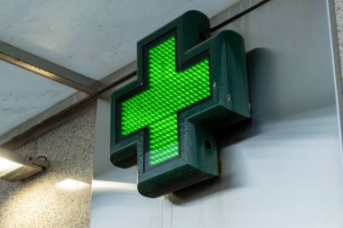 Yeşil LED 'lerle aydınlatılmış çapraz şekilli bir eczane paneli..
