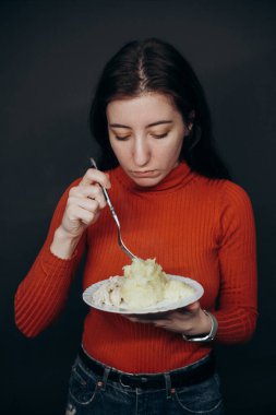 Kıvırcık saçlı, patates cipsi yiyen, evde oturan güzel mavi gözlü manken.