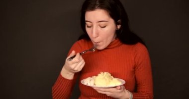 Kıvırcık saçlı, patates cipsi yiyen, evde oturan güzel mavi gözlü manken.