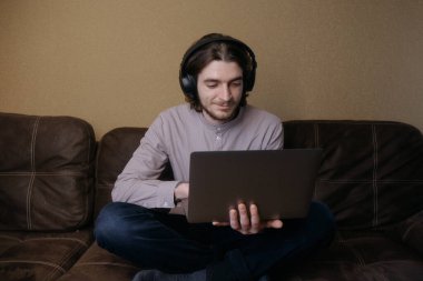 Ukraynalı adam evde dizüstü bilgisayarla çalışıyor.