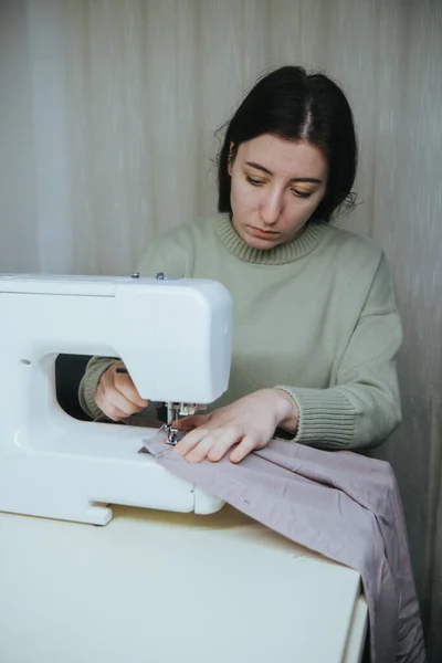 Woman sews on a typewriter at home — Stock Photo, Image