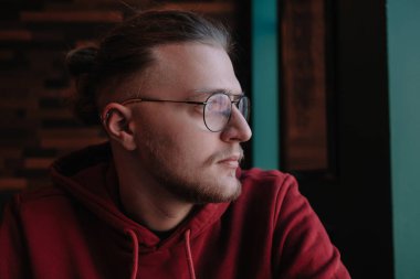 İnternette çalışırken kameraya gülümseyen görme düzeltmesi için optik gözlüklü mutlu erkek serbest yazar portresi, kafede oturan neşeli hipster blogcu ve sahte dizüstü bilgisayar.