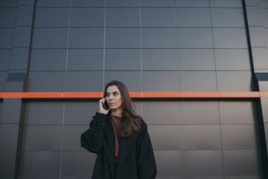 Esmer, tatlı kız telefonda konuşuyor.