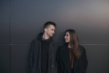 Siyah endüstriyel arka planda kahve içen genç çift.