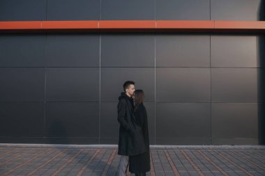 Siyah endüstriyel arka planda kahve içen genç çift.