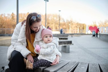 Yedek kulübesinde bebeğiyle genç bir anne.