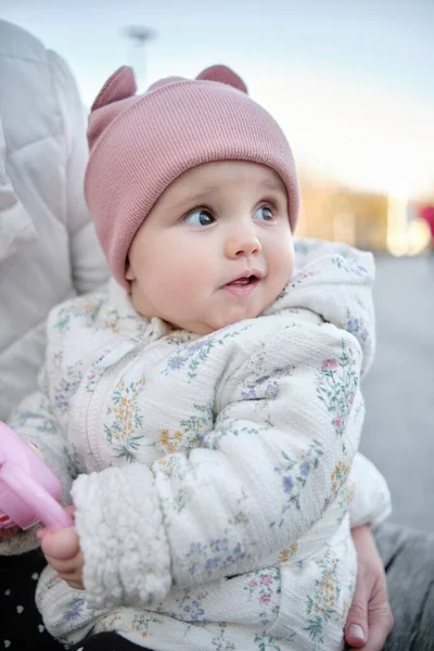 Mamãe segura o bebê e brinca com ele na rua. Seis meses de idade bebê em um chapéu — Fotografia de Stock