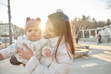 Açık havada mutlu ve uyumlu bir aile. Annem bebeği kusar, güler ve yazları oynar.