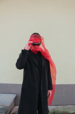 Kırmızı maskeli ve güneş gözlüklü süper kahraman. Sarı arka planda moda savaşçısı.