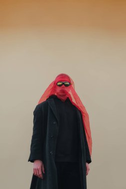 Kırmızı maskeli ve güneş gözlüklü süper kahraman. Sarı arka planda moda savaşçısı.