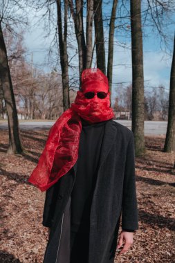 Kırmızı maskeli ve güneş gözlüklü süper kahraman parkta moda savaşçısı.