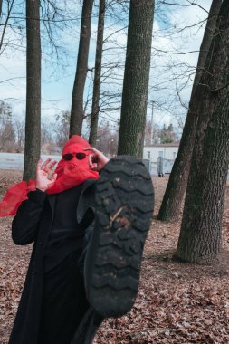 Kırmızı maskeli ve güneş gözlüklü süper kahraman parkta moda savaşçısı.