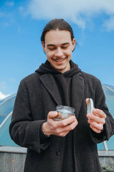 若いゲイのヒップスターが路上で幸せなサングラス笑みを浮かべてピーナッツを食べる 健康的なライフスタイル — ストック写真