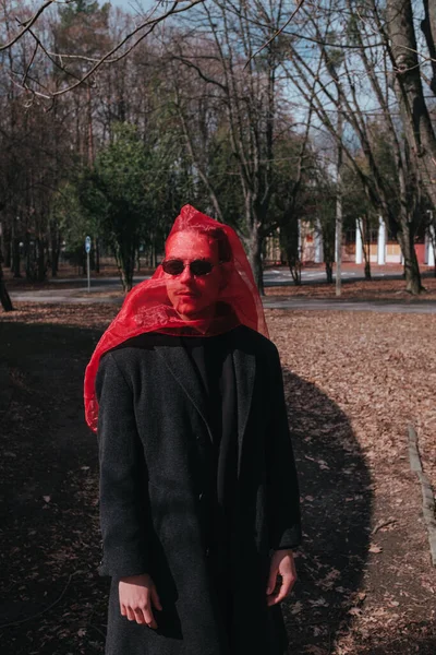 Kırmızı maskeli ve güneş gözlüklü süper kahraman parkta moda savaşçısı.