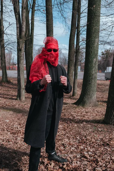 Kırmızı maskeli ve güneş gözlüklü süper kahraman parkta moda savaşçısı.