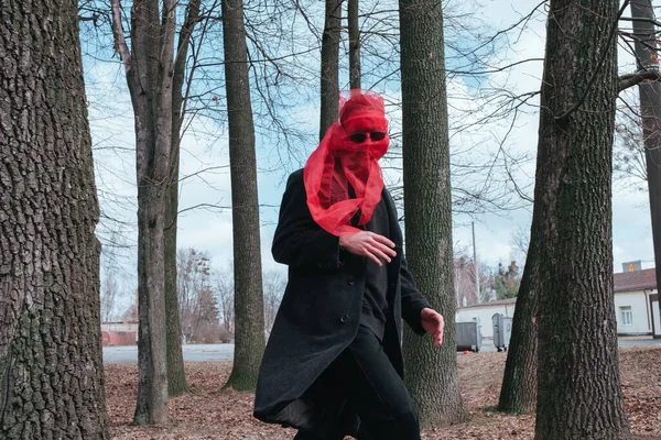 Kırmızı maskeli ve güneş gözlüklü süper kahraman parkta moda savaşçısı.