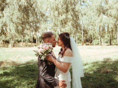 Mutlu evlilik çifti botanik parkında yürüyor. Tahıl efekti otantik.