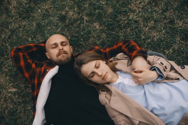 Çimlerin üzerinde yatan genç bir çift. Yaz aşkı