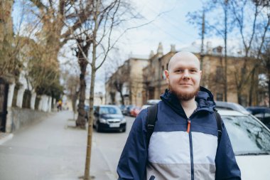 Kel kafalı ve sakallı beyaz bir adam parkta dinleniyor.