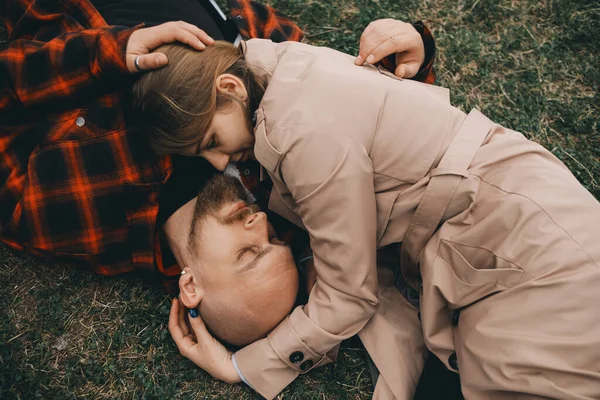 Νεαρό ζευγάρι ξαπλωμένο στο γρασίδι. καλοκαιρινή αγάπη — Φωτογραφία Αρχείου