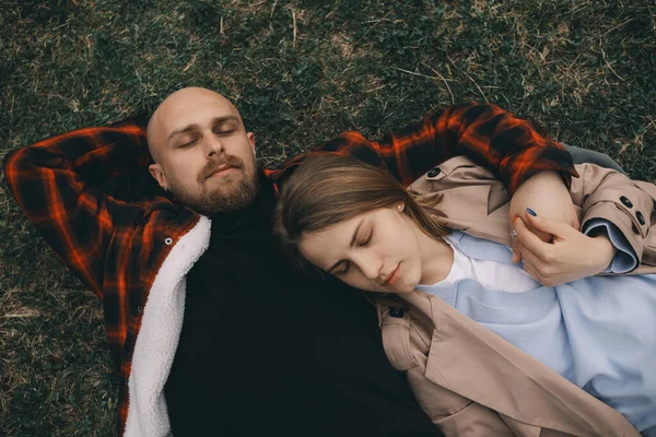 Νεαρό ζευγάρι ξαπλωμένο στο γρασίδι. καλοκαιρινή αγάπη — Φωτογραφία Αρχείου