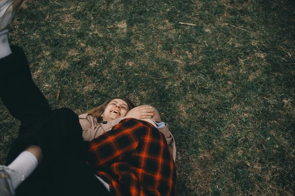 年轻夫妇躺在草地上。夏天的爱情 — 图库照片