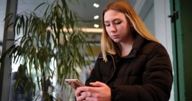 Kafede oturan akıllı telefonunda çalışan bir kız.