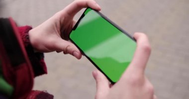 Asya kadınlarının elindeki boş dijital akıllı telefon, telefon yeşil ekran