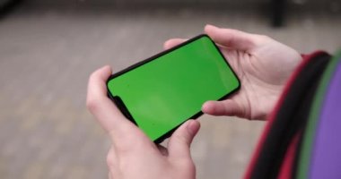 Asya kadınlarının elindeki boş dijital akıllı telefon, telefon yeşil ekran