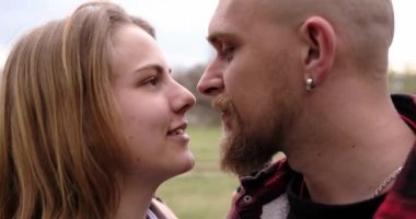 Birbirini seven çiftler birbirlerine sarılırlar. Arkaplanda ağaç